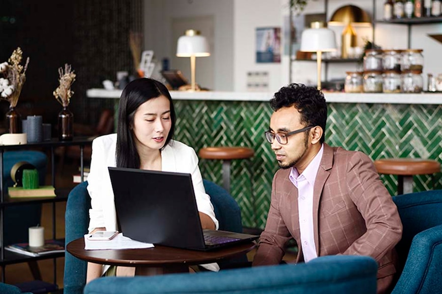 man and woman looking at a laptop at a table at a restaurant